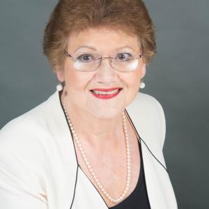 Lyla head and upper body shot with cream colored jacket and black underblouse