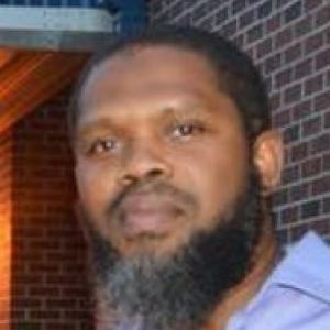 Headshot of a Middle-aged Black man with a beard wearing a collared shirt.